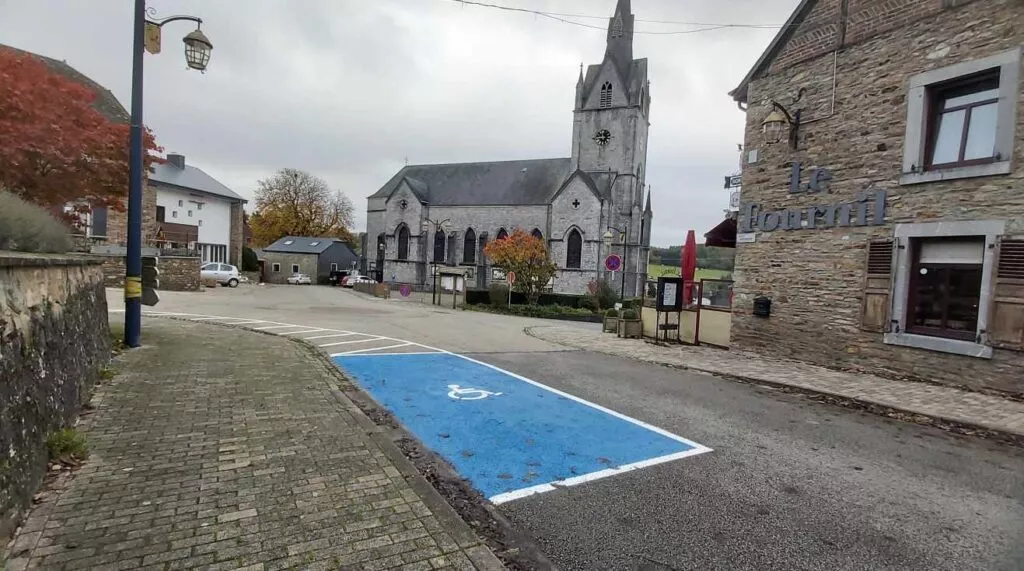 Vue d'une place de parking PMR dans le centre du village de Redu